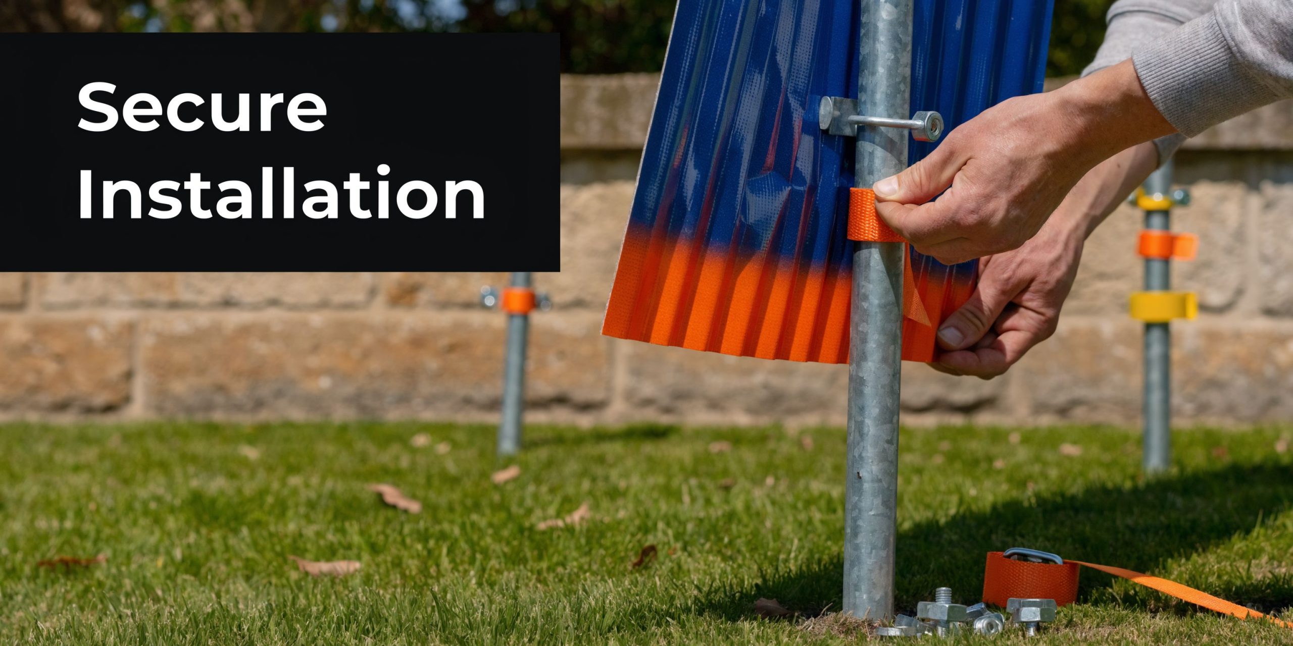 A person securely installing a corrugated plastic sign onto a metal post in a grassy area.