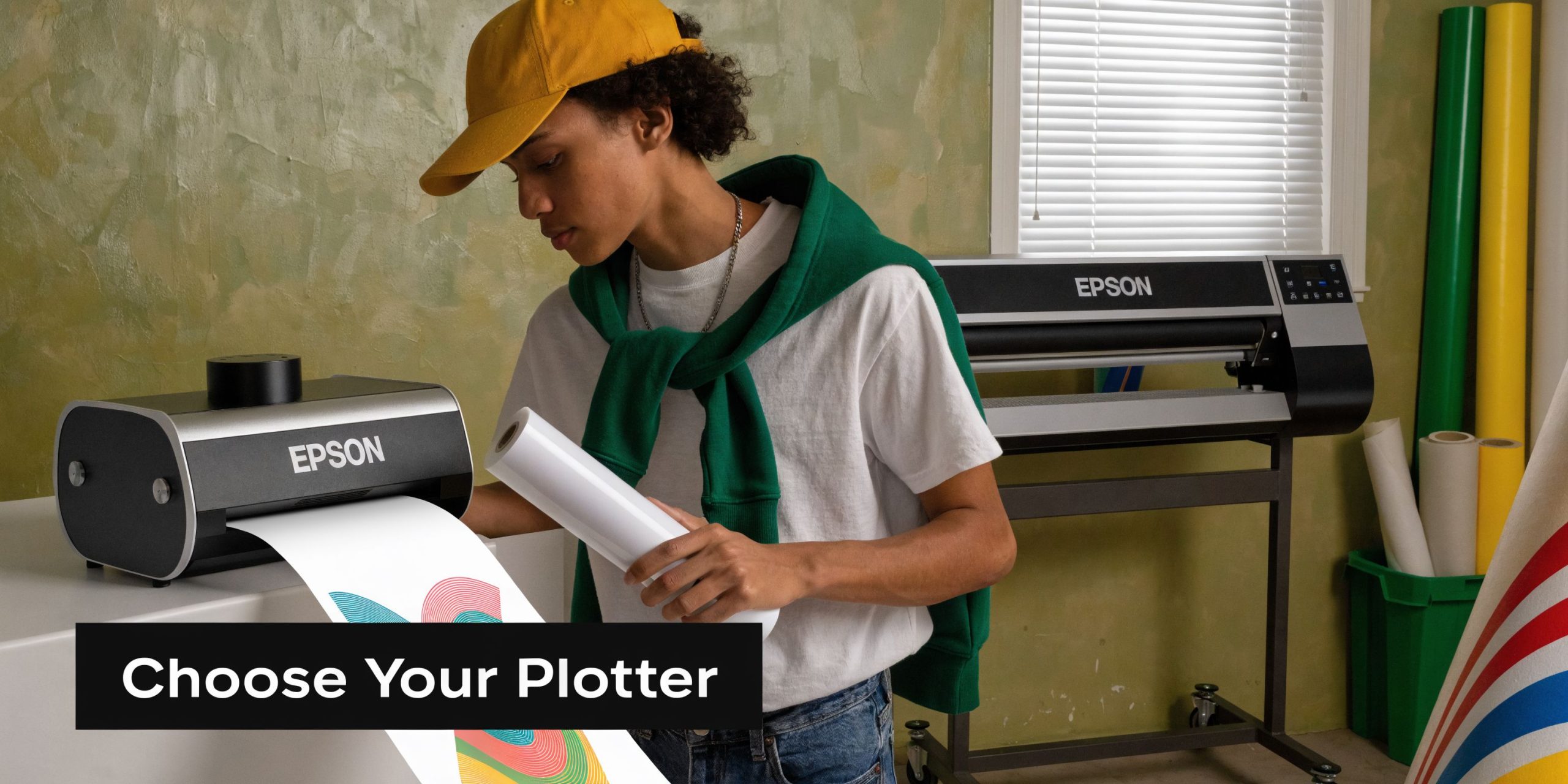 A young man preparing a roll of material on an Epson wide format plotter printer.