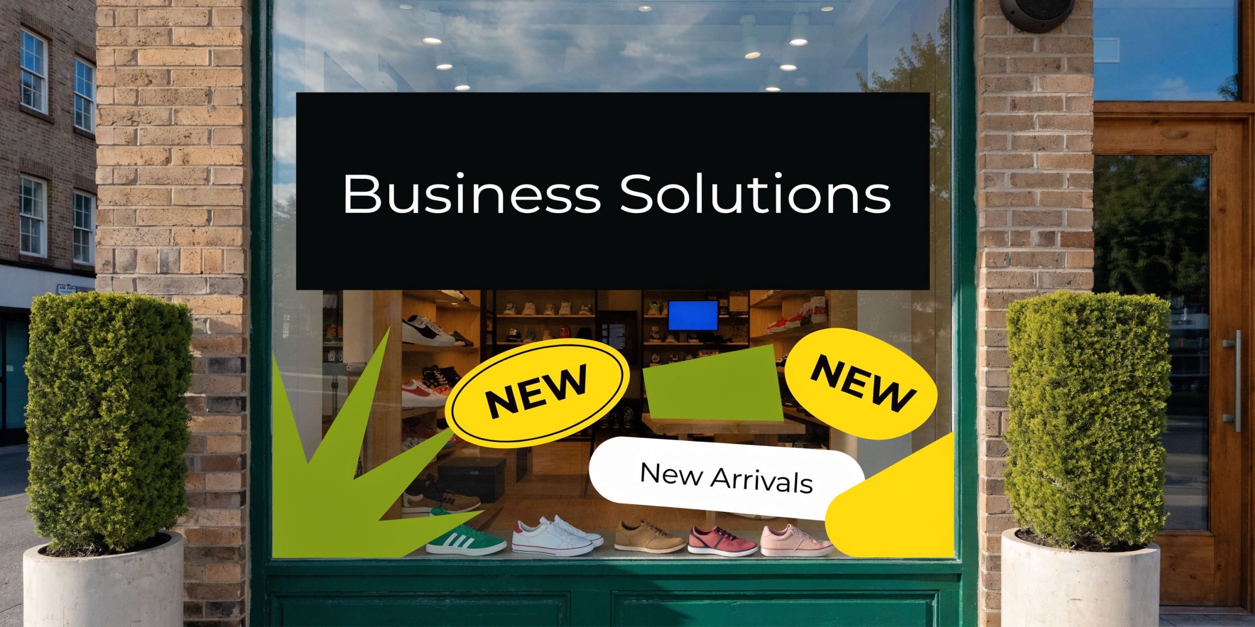 A storefront window featuring a Business Solutions sign and a New Arrivals display with various sneakers.
